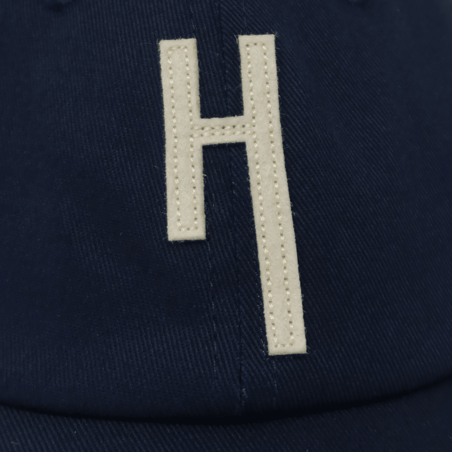 Hang Dry ballcap editorial detail — stitched H patch logo highlighting premium construction