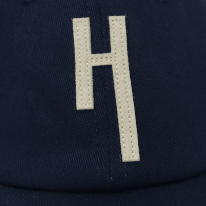 Hang Dry ballcap editorial detail — stitched H patch logo highlighting premium construction