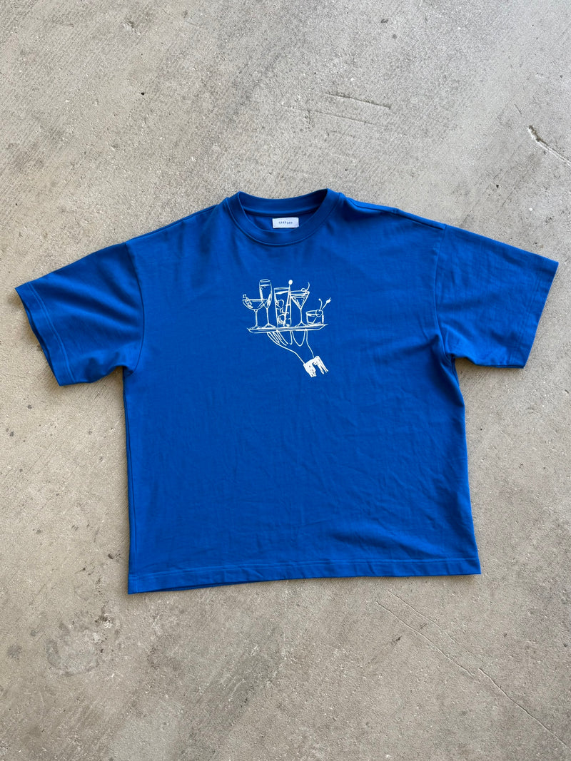 Hang Dry Studio Blue Sunday Dinner tee flat lay — overhead product shot on concrete