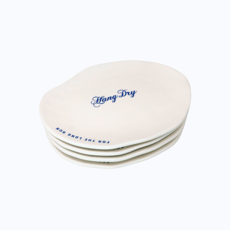 Four Hang Dry Sunday Dinner Luncheon Plates arranged together — organic-shaped white ceramic with logo