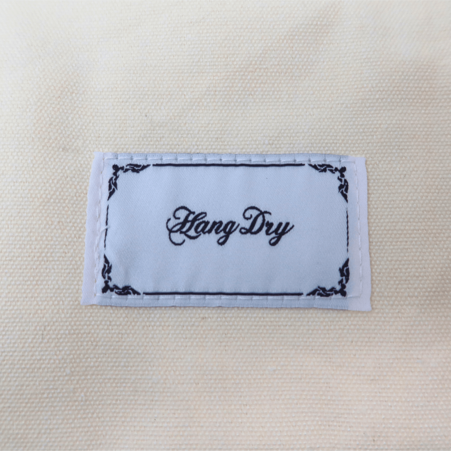 Hang Dry brand tag attached to the Sunday Dinner white tote bag