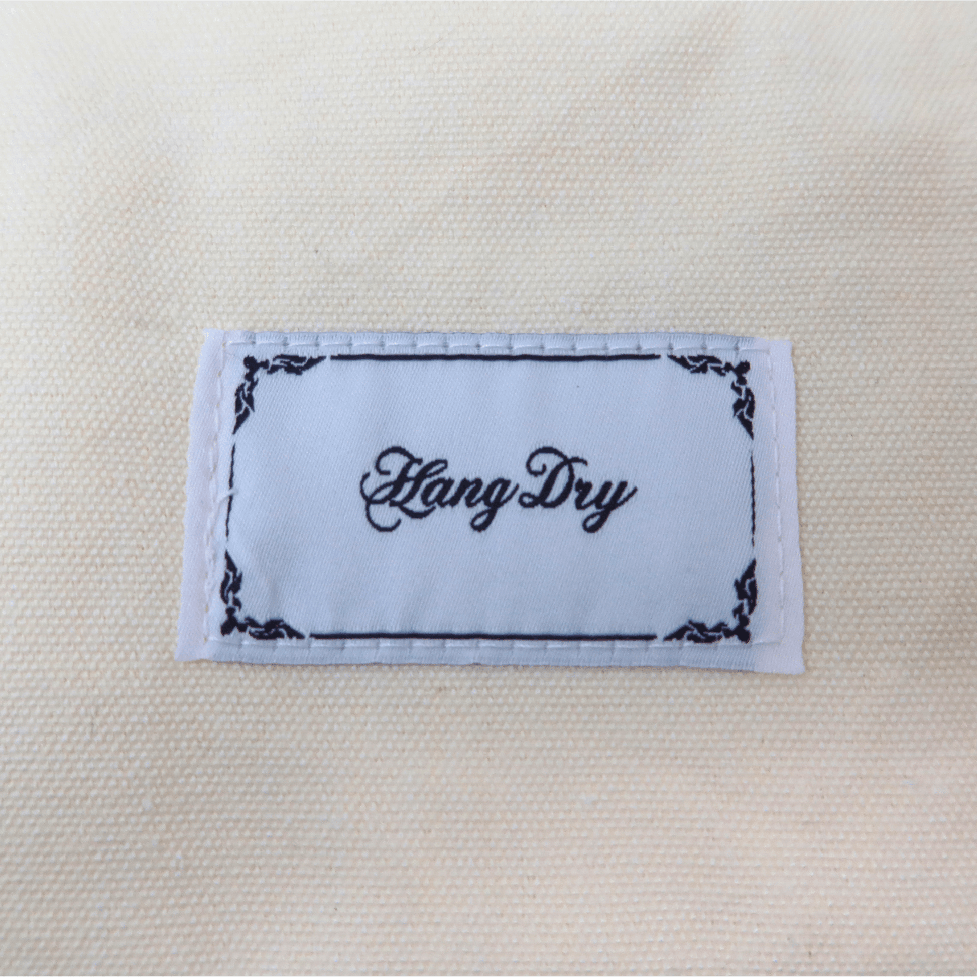 Hang Dry brand tag attached to the Sunday Dinner white tote bag